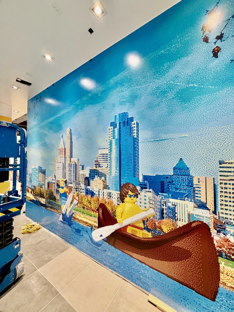 City mural-style hoarding graphics wrapping a retail construction barrier