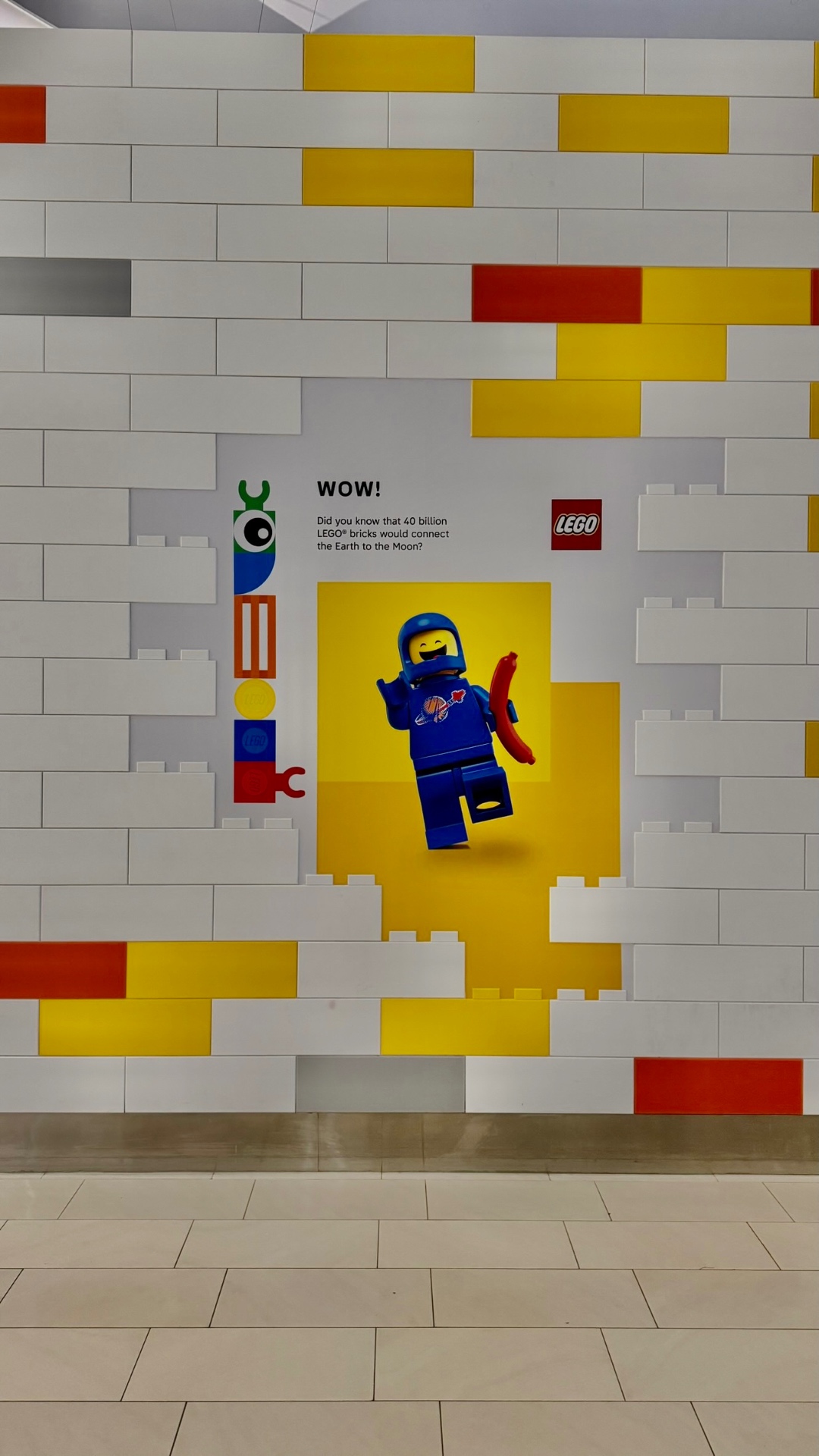 LEGO mosaic hoarding graphics wrapping a corner retail unit in a mall