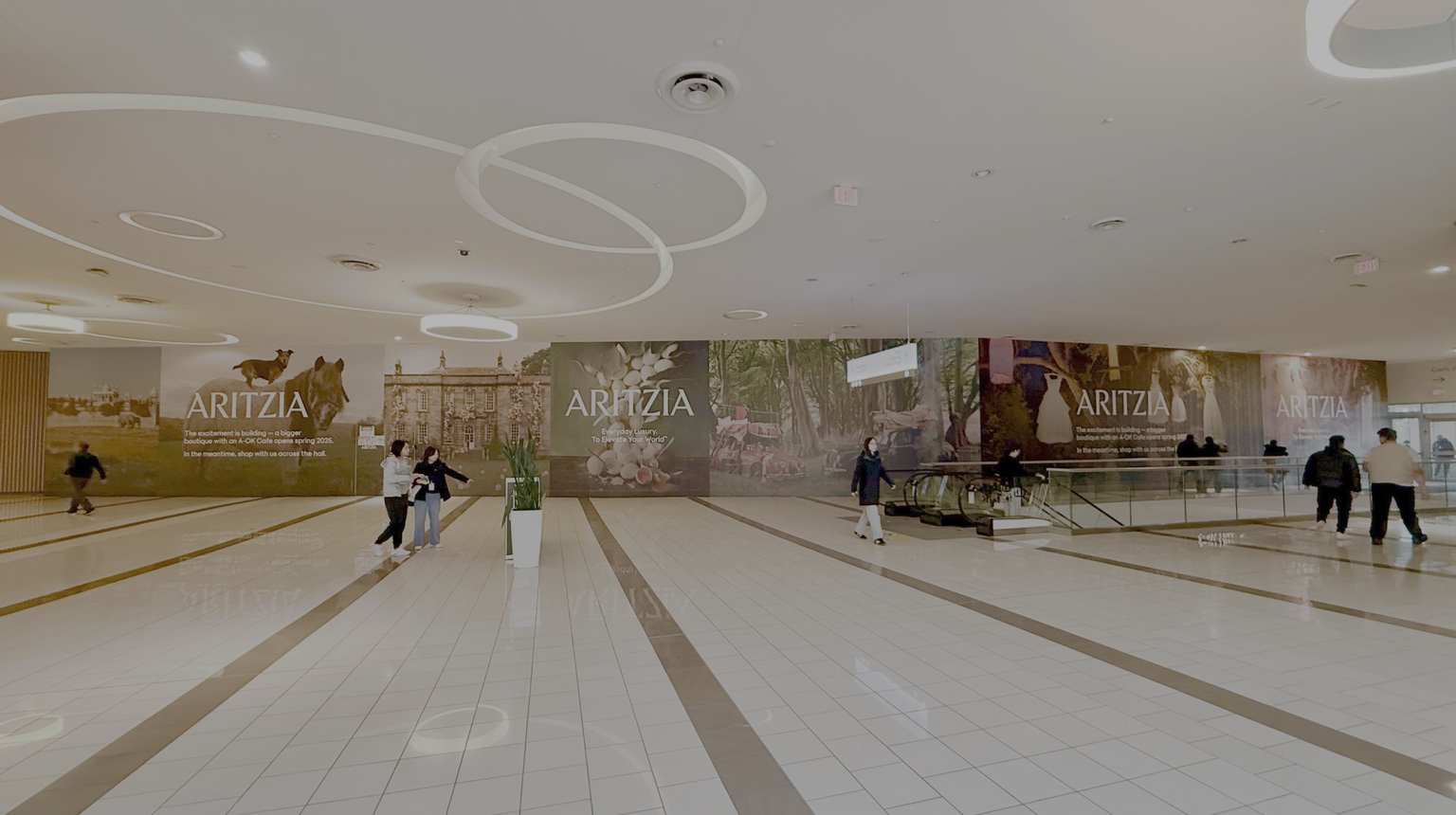 Large Aritzia hoarding graphic in a mall concourse